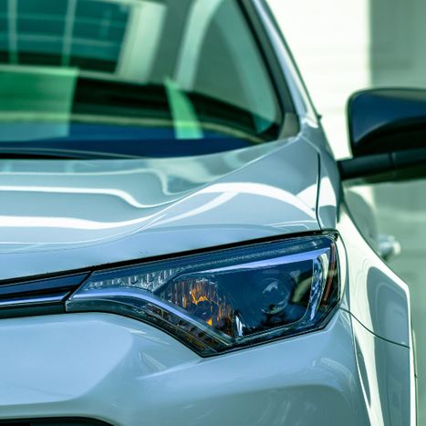 Closeup of headlight and windshield with tint