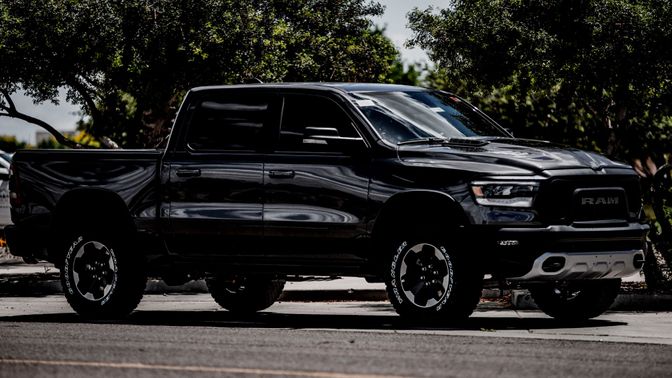 Large black truck driving on the road