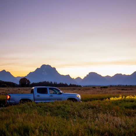 truck driving past mountains at twilight