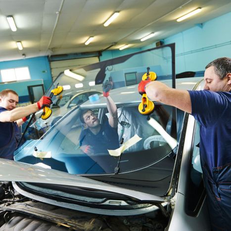 An auto glass team changes out a car windshield