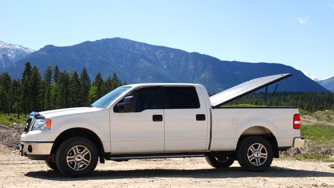 white truck with its bed cover propped open