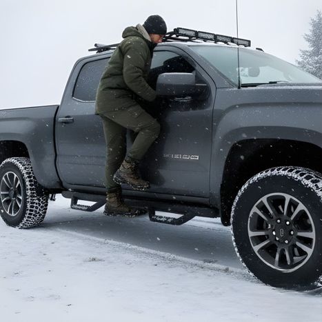 Truck owner using step bars on the snow.