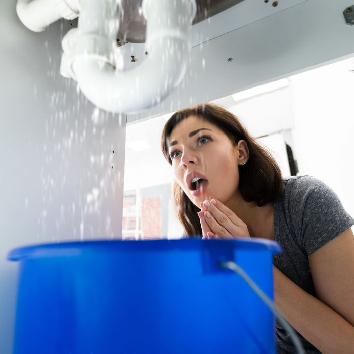 woman looking at a leaking pipe