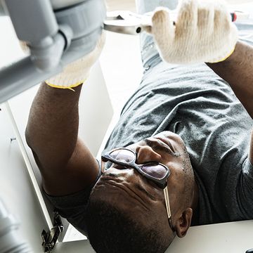 Plumber working under a sink