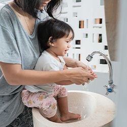 parent washing young child's hands