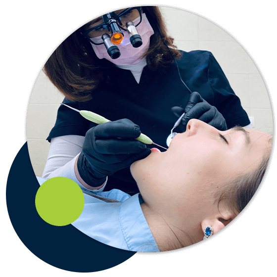 dentist providing young woman with dental cleaning