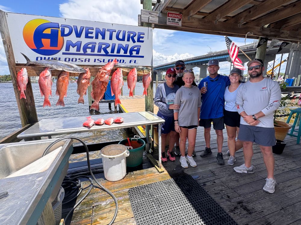 Family-friendly fishing charter guest holding a grouper catch in Destin, Florida
