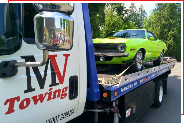 MV Towing with a green sedan on the flatbed