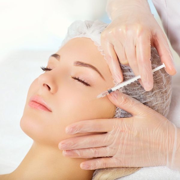 Woman getting a facial injection in her cheeks.