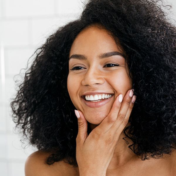 woman looking at her smooth face in mirror, hand on chin