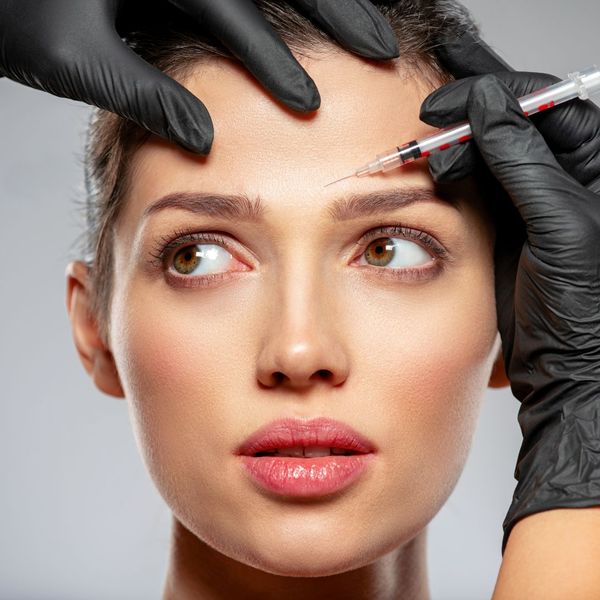 Woman getting injections above her eyebrows. 