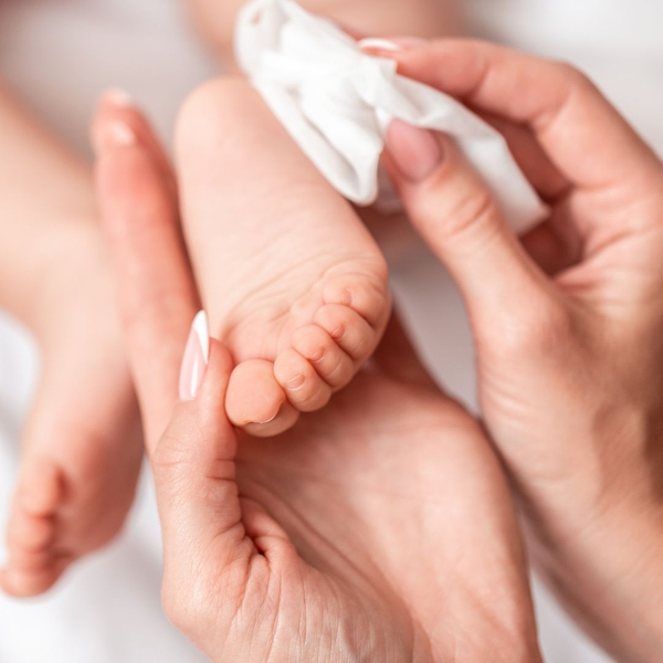 mother cleaning baby's feet with wipe