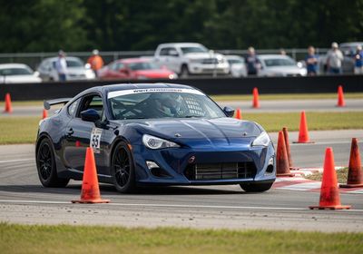 Blue Race Car Navigating Cones on Racetrack