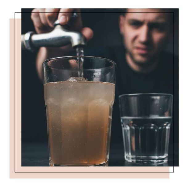 man filling cup with dirty water from faucet, looking a little disgusted