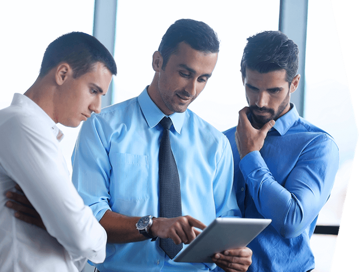 a group of businessmen looking at a tablet