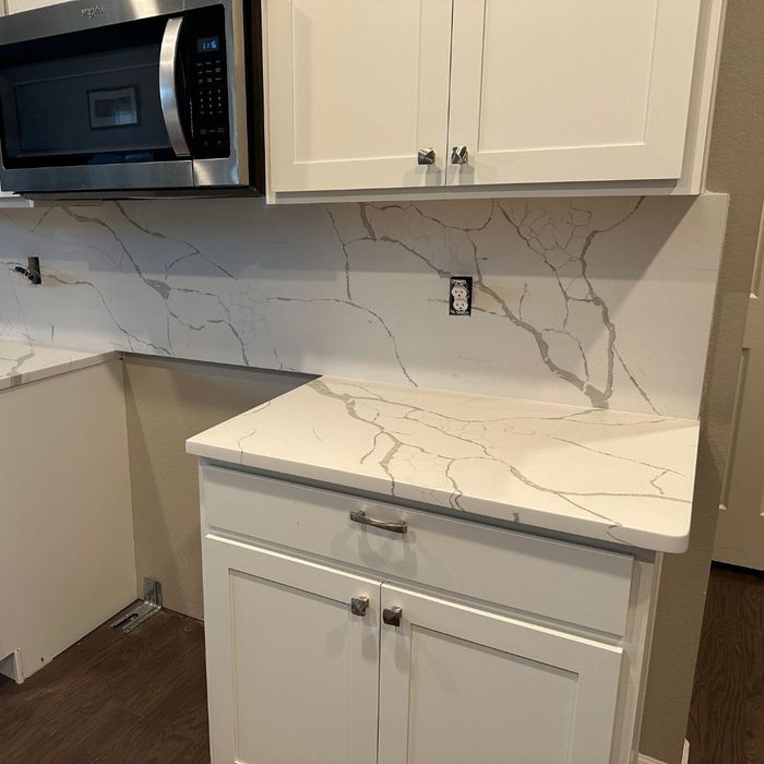 white and grey countertops and backsplash in a kitchen