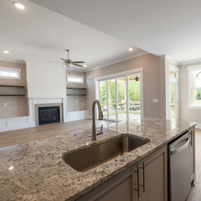 A kitchen with brown granite countertops