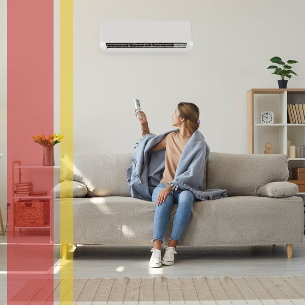 Women enjoying fresh air in her living room with air conditioner on the wall.
