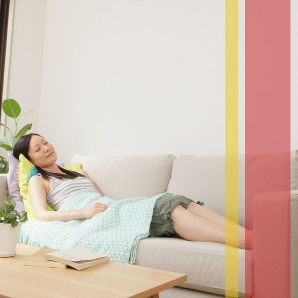 woman naps on the couch in a comfortable temperature controlled room 