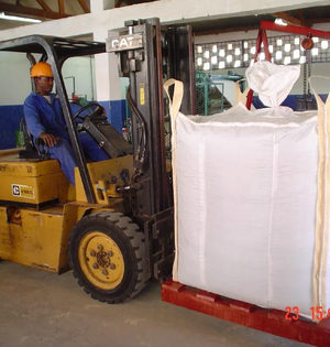 Man operating a forklift holding a bulk industrial bag