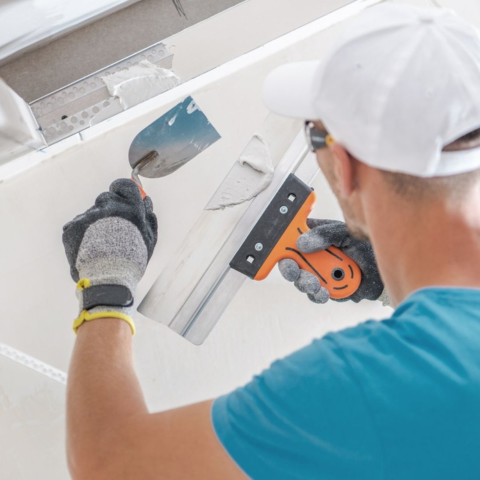 Man repairing ceiling with drywall 