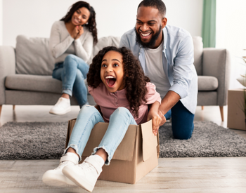 image of a happy family with father and daughter playing with moving boxes 