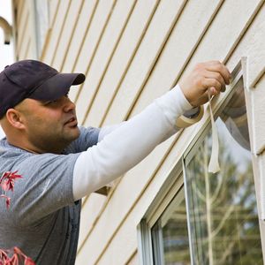 a painter applying paint tape Exterior Painting Image Icon (2).jpg