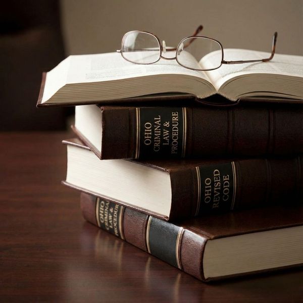 Stack of legal books and glasses representing the legal definition of aggravated assault.