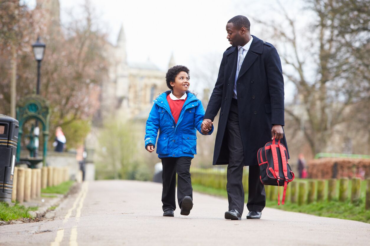 man walking holding child's hand