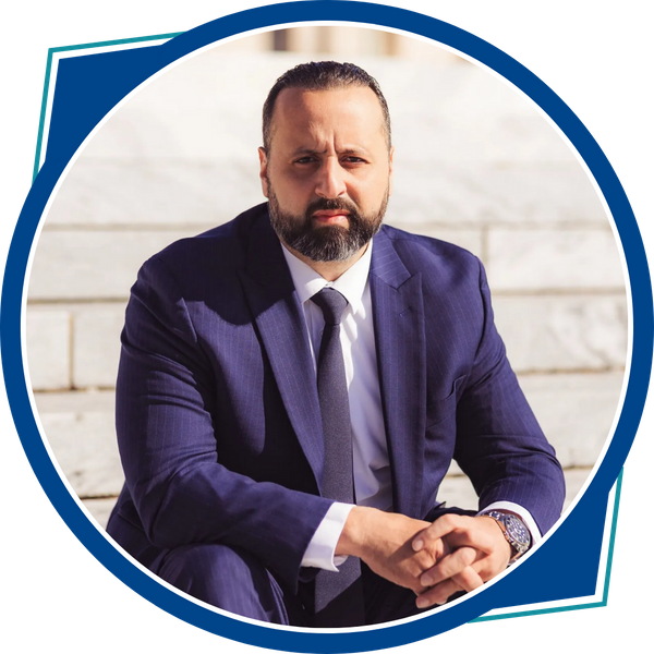 issa elkhatib sitting on courthouse steps, hands clasped, blue suit