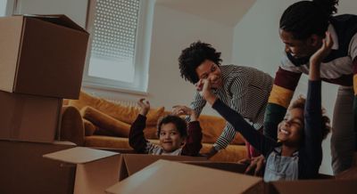 couple pushing children in moving boxes