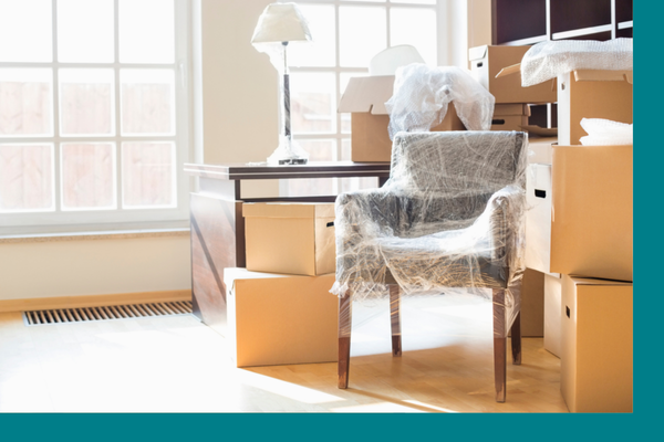 A stack of moving boxes and a bubble wrapped office chair