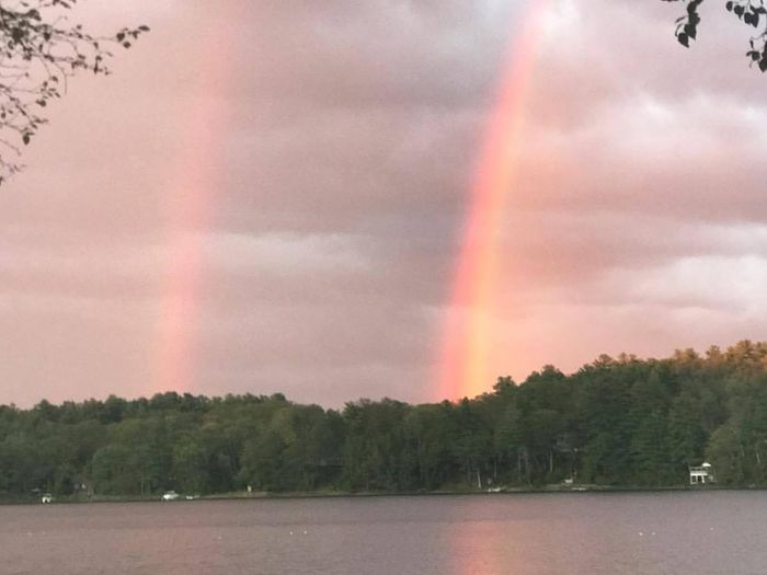 Double rainbow arching over a beach.