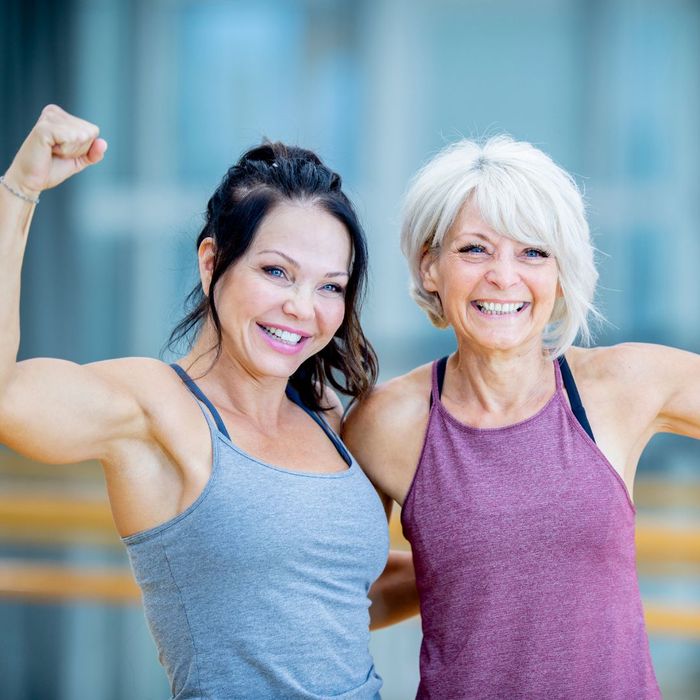 a young and older woman showing off their muscles