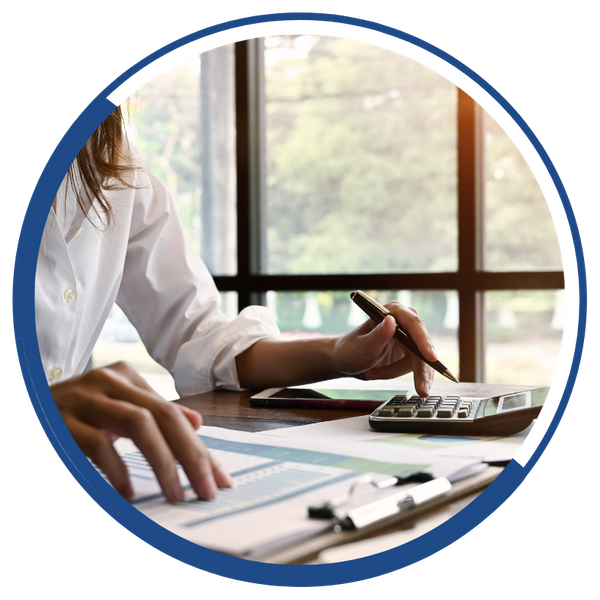 woman looking at paperwork and typing on calculator