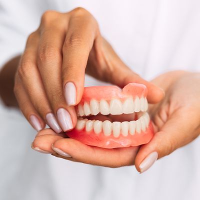 close up of dentures in hands