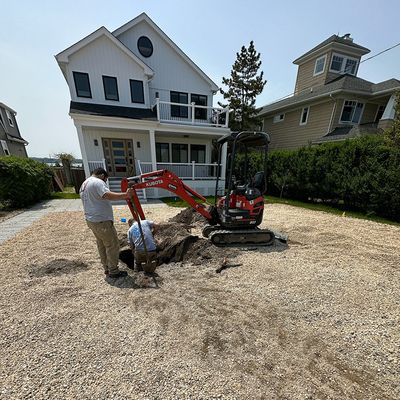 backhoe digging sand in yard