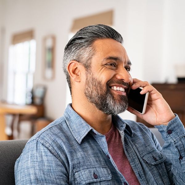 man smiling while on the phone