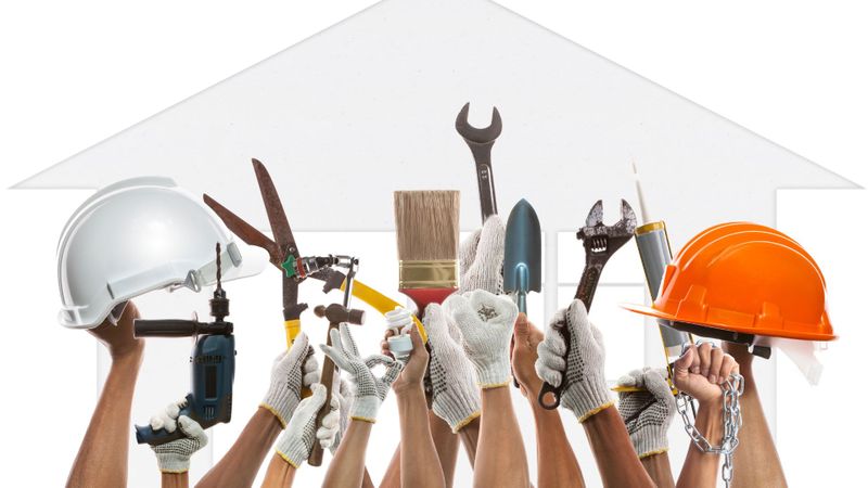 people holding up a variety of tools and hard hats