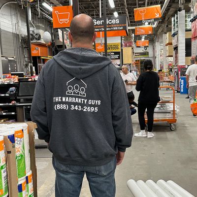man wearing The Warranty Guys hoodie in hardware store