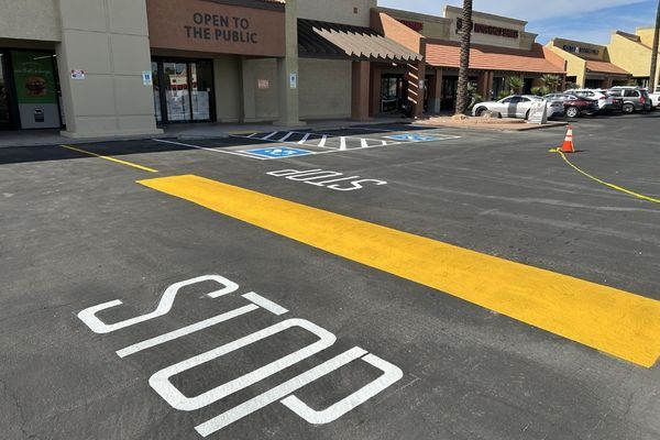 Stop painted on the ground before a speed bump in a parking lot