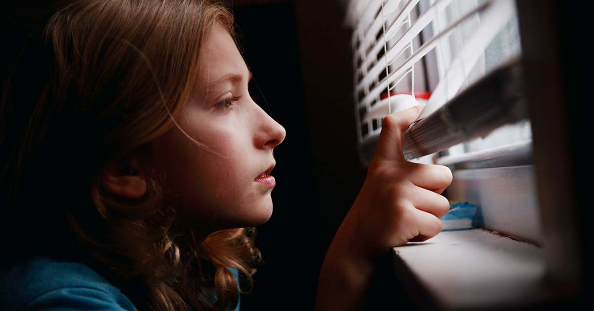 young girl staring out a window