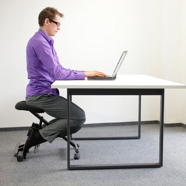 a man sitting straight at his desk How To Get The Most Out of Chiropractic Adjustments (3).jpg