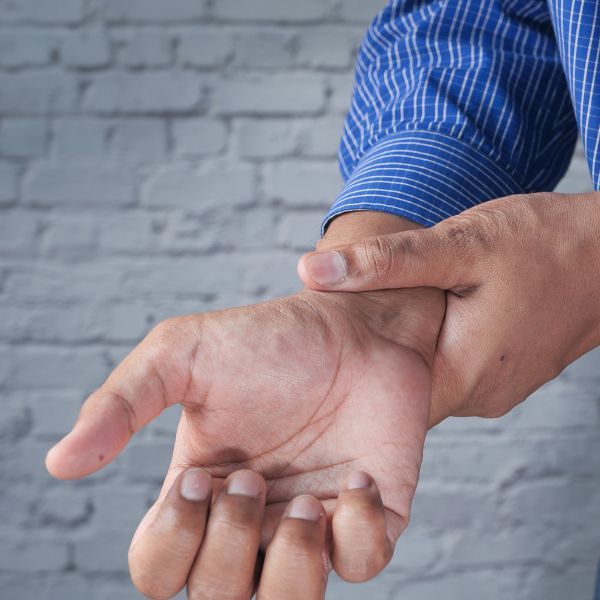 a person holding their hand in pain When to Seek Chiropractic Care for Neck Pain (4).jpg