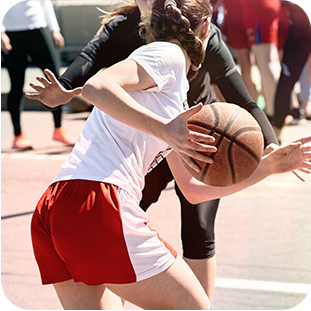 Women playing basketball outside.