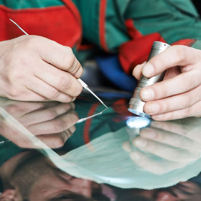 person repairing windshield crack person repairing windshield crack