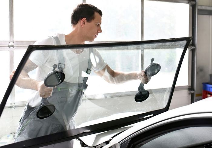 man replacing windshield