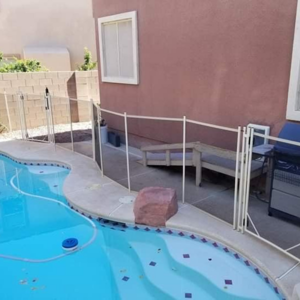 A white temporary fence around a pool