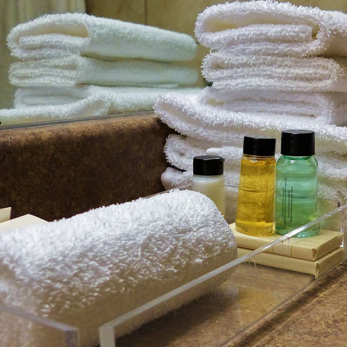 Stack of towels next to a variety of soaps. 