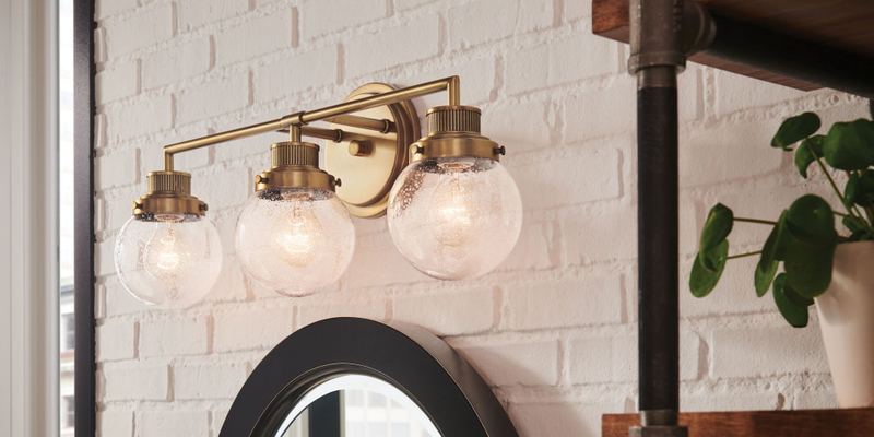 brass fixtures above bathroom mirror
